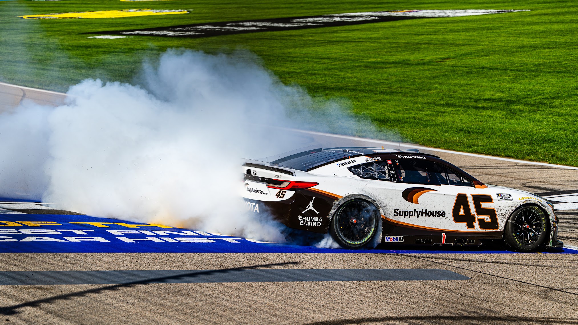 Tyler Reddick's No. 45 Toyota doing a burnout, smoke pouring off the rear tires
